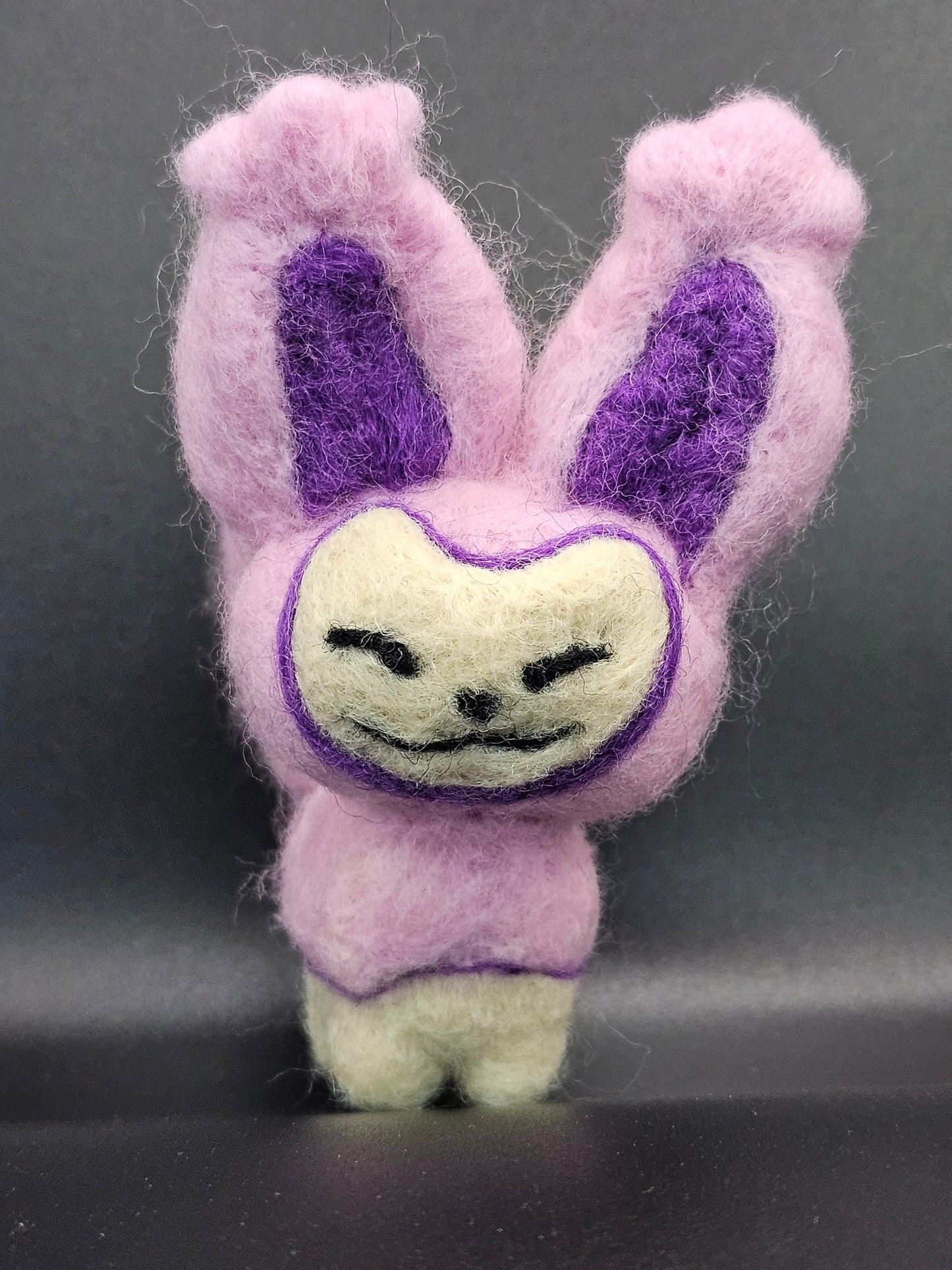 Skitty is a a pink cat with tall ears and a tail that looks sort of like a balloon on a string, with more balloons hanging from it. Features are outline with purple, and interior of ears is purple.