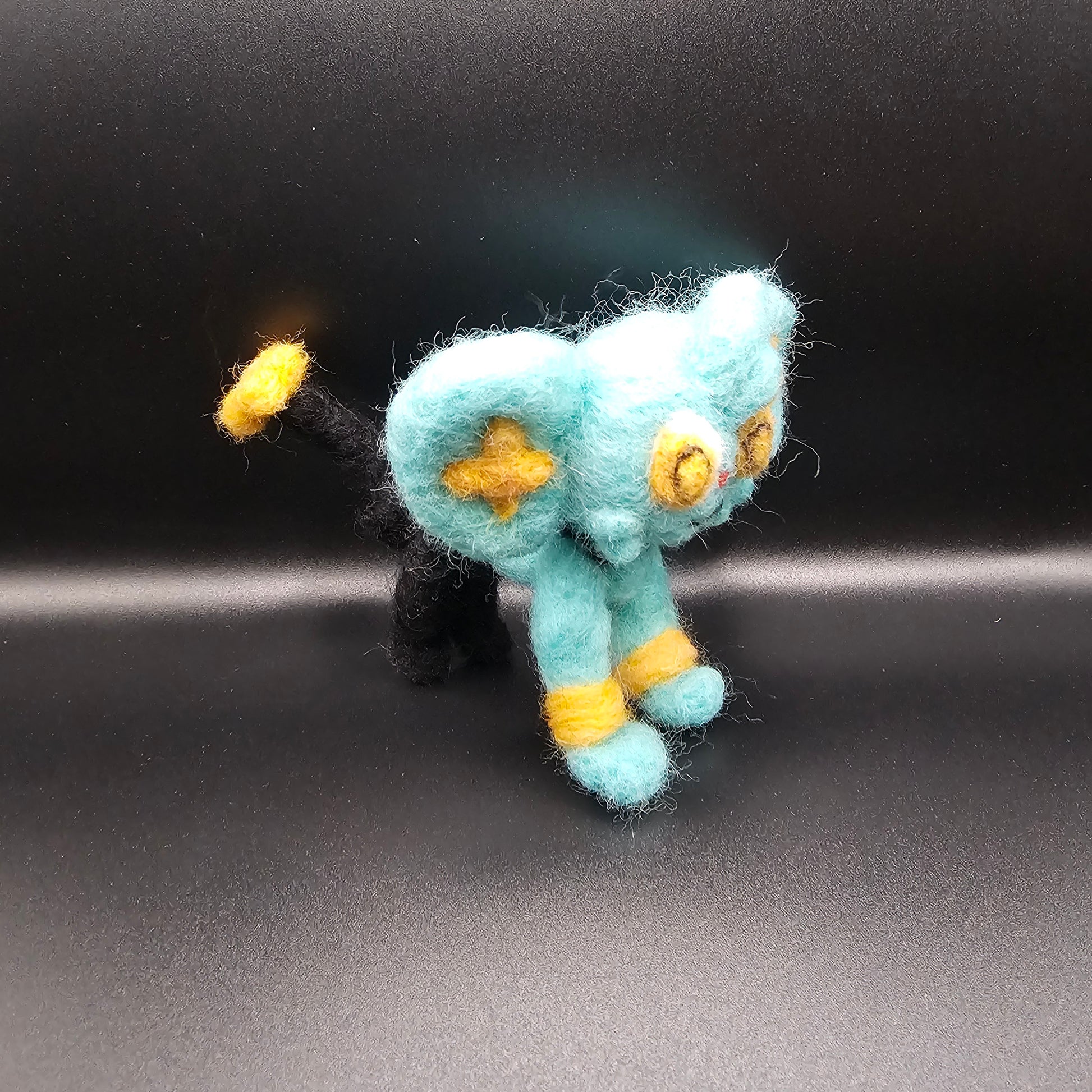 Skitty is a a pink cat with tall ears and a tail that looks sort of like a balloon on a string, with more balloons hanging from it. Features are outline with purple, and interior of ears is purple.