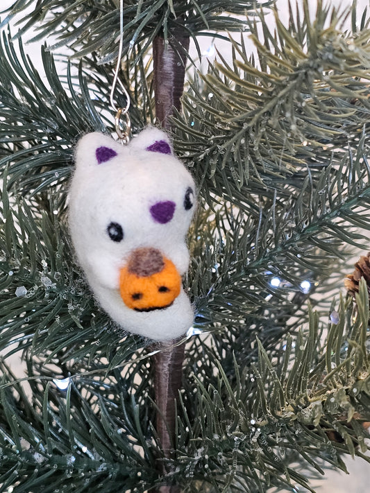 Needle-felted ghost with cat ears and nose. Inside of ears and nose are purple. Ghost cat is holding a tiny Jack-o'-lantern. Pictured hanging in a Christmas tree.